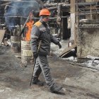 Andriy, un electricista, cerca de los barriles con leña encendida, instalados para calentar la sección dañada de una planta de energía térmica en Ucrania después de los ataques rusos.