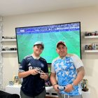 Ahidam (i) y su padre comparten la afición por Emelec y el fútbol hasta en los videojuegos.