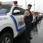 Policías permanecen junto a patrulleros durante un operativo de seguridad en Quito.