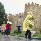 Fotografía de referencia, varias personas se protegen de la lluvia en España.