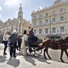 Fotografía del 29 de enero de 2026 que muestra a turistas montando en un coche alado por un caballo en La Habana (Cuba).