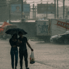 Referencial. Ciudadanos se resguardan bajo paraguas mientras las fuertes lluvias cubren las calles, en medio de la alerta emitida por el Inamhi para varias zonas del país.