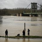 Personas en un sendero rodeado de una zona inundada en Marmande, suroeste de Francia, el 12 de febrero de 2026, mientras la tormenta Nils provoca inundaciones excepcionales a lo largo del río Garona.