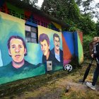 Otilia Torres, hermana de Diuviseldo Torres, camina frente a un mural que representa a su hermano y otras personas desaparecidas en el municipio de Fusagasugá.
