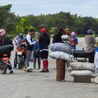 Venta. Personas compran carbón en una carretera de La Habana. Así, se esfuerzan por sobrellevar apagones constantes y escasez que empeoran bajo la presión económica de EE.UU.