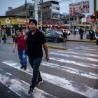Personas caminan por una avenida en Lima (Perú).