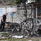 Un policía israelí inspecciona los restos de un vehículo incendiado después de que Israel interceptara un misil balístico de Irán, este domingo 15, en Tel Aviv.