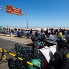 Policías peruanos (d) y chilenos vigilan a cientos de migrantes varados en la frontera, en Arica (Chile).