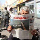 Mientras Estados Unidos continúa reforzando su presencia militar en Oriente Medio, un hombre lee el diario iraní  con el titular "Sorpresas marítimas".