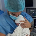 Carlos Scavone lleva en brazos a su hija.