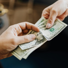 Referencial. La entrega de billetes refleja el pago de obligaciones laborales, como el décimo tercero y cuarto sueldo en Ecuador.