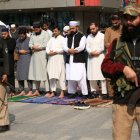 Oficiales de seguridad y musulmanes civiles en una calle de Peshawar, en Pakistán.