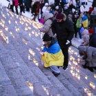 La gente enciende velas durante una manifestación que conmemora el cuarto aniversario de la invasión rusa en Ucrania. Helsinki, Finlandia, el 24 de febrero de 2026.