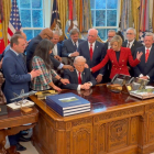 Donald Trump aparece sentado detrás de su escritorio, mientras un grupo de pastores evangélicos coloca sus manos sobre él y eleva una oración.