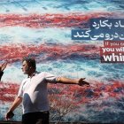 Iraníes conversan frente a un cartel antiestadounidense en Teherán, Irán, el 25 de febrero de 2026.