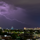 Referencial. Un rayo ilumina el cielo nocturno sobre la ciudad, mientras Inamhi advierte tormentas y lluvias en la Costa y Amazonía este 19 de febrero