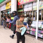 Una mujer revisa la factura de la medicina que ha comprado sorprendida de que ahora cuesta más.