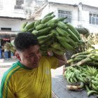 Un trabajador lleva un racimo de plátano para un depósito ubicado en el suroeste de Guayaquil.