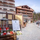 Velas y flores colocadas en la entrada del bar "Le Constellation", con sus ventanas cubiertas por paneles de MDF y selladas por la Policía, en Crans-Montana, este 8 de febrero.