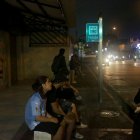 Jóvenes esperan casi una hora hasta que pase el bus que los lleve a su casa. Son las nueve de la noche.