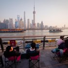 Fotografía de archivo de un grupo de personas frente al paisaje urbano de Shanghai.