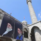 Un hombre limpia una valla publicitaria del nuevo líder supremo de Irán, el ayatolá Mojtaba Khamenei (derecha), y al difunto ayatolá Ruhollah Khomeini (izquierda),  en Cachemira, India, el 24 de marzo de 2026.