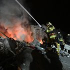 Los bomberos extinguen un incendio y limpian los escombros de un edificio residencial de cinco pisos que fue alcanzado por un misil balístico en Járkov, el 7 de marzo de 2026.