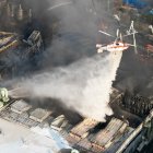 Un helicóptero de extinción de incendios arroja agua para sofocar un incendio en una fábrica de autopartes en Daejeon, el viernes 20 de marzo de 2026.