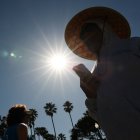 Una persona lleva un sombrero para protegerse del sol matutino mientras camina por The Strand en Redondo Beach, California, el 20 de marzo de 2026, durante una ola de calor.