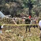 Varias personas y soldados se encuentran junto a los restos de un avión Hércules de la Fuerza Aérea que se estrelló durante el despegue, en Puerto Leguizamo (Colombia), el 23 de marzo de 2026.