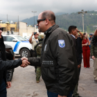 El presidente Daniel Noboa estrecha la mano del ministro del Interior, John Reimberg, durante un acto oficial acompañado por personal militar.