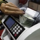 Una foto referencial de financiamiento para Ecuador, en la foto una máquina que cuenta billetes.