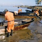 Fotografía de referencia de trabajadores petroleros contratados por la paraestatal Petróleos Mexicanos que limpian en una zona de un derrame de crudo.