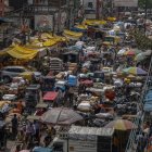 Personas y vehículos transitan por una calle congestionada en un mercado mayorista del casco antiguo de Nueva Delhi.