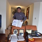 Jonnathan Carrera con varios  fotos de su padre y de los reconocimientos que recibió por su aporte para la identidad, normativa y masificación del ecuavóley.