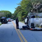 Agentes de policía custodian el perímetro tras el choque de la camioneta negra perteneciente a Tiger Woods
