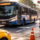 Un bus de transporte público circula por una intersección urbana mientras agentes realizan controles de tránsito para prevenir infracciones y siniestros viales.
