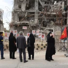 Varias personas se reúnen para observar fotografías de los fallecidos en un ataque aéreo estadounidense-israelí contra un edificio residencial, expuestas frente al mismo edificio que fue alcanzado en Teherán, Irán, el 13 de abril de 2026.
