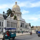 Un triciclo y varias motocicletas eléctricas circulan frente al Capitolio este martes 14 de abril de 2026,en La Habana (Cuba).