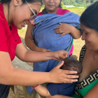 Médica aplica dosis de vacunas a un bebé, en una población de Ecuador.