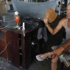 En el sur de Guayaquil, moradores del suburbio intentaron aliviar el calor con cualquier objeto ante la falta de energía eléctrica, que les impedía encender ventiladores.