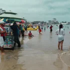 Turistas y locales disfrutan de un día de playa durante un feriado en la costa de Ecuador.