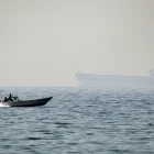 Una lancha motora navega a lo largo de la costa frente a la ciudad de Al Jeer, en el estrecho de Ormuz, en el emirato norteño de Ras Al Khaimah.