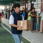 Integrante de la Oficina Nacional de Procesos Electorales (ONPE) carga una caja para empezar la instalación de una de las mesas de votación en un colegio de Lima.