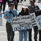 Personas sostienen carteles durante la masiva marcha por el Día Internacional del Trabajo, este viernes 1 de mayo de 2026, en Quito.