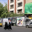 Mujeres caminan junto a pancartas instaladas a lo largo de la carretera con imágenes del asesinado líder supremo de Irán, el ayatolá Ali Khamenei (izquierda), y del líder supremo, el ayatolá Mojtaba Khamenei, en Teherán.