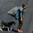 Un hombre camina junto a un perro por una calle del bulevar Fuerzas Armadas este jueves, en Tegucigalpa (Honduras).