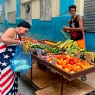 Una mujer vestida con los colores de la bandera de Estados Unidos compra frutas a un vendedor ambulante este viernes, en una calle de La Habana (Cuba).