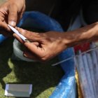Un vendedor enrolla hojas de molokhia, también conocidas como malva de yute, que normalmente se usan en la cocina, para hacer un cigarrillo el 19 de abril de 2026.