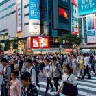 Fotografía de personas transitando un paisaje urbano en Japón.